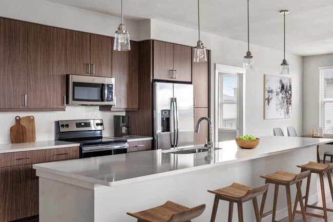 A kitchen island seats four and still leaves room to prep and plate up. - Gateway Arvada Ridge