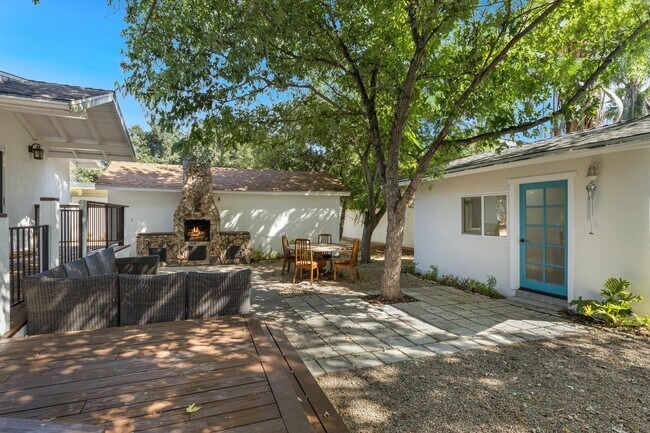 Back yard with mature trees, outdoor fire place , large deck and detached room - 228 N Pueblo Ave