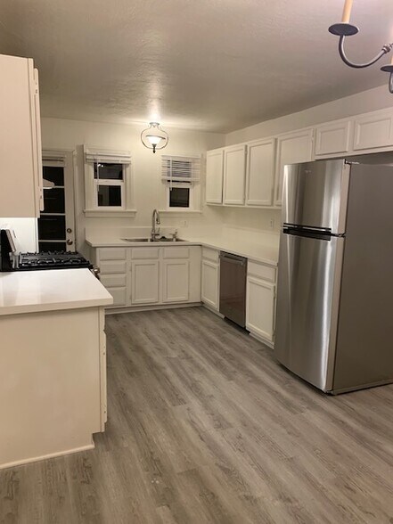 Wide view of kitchen with quartz countertops, and stainless steel appliances. - 24606 University Ave