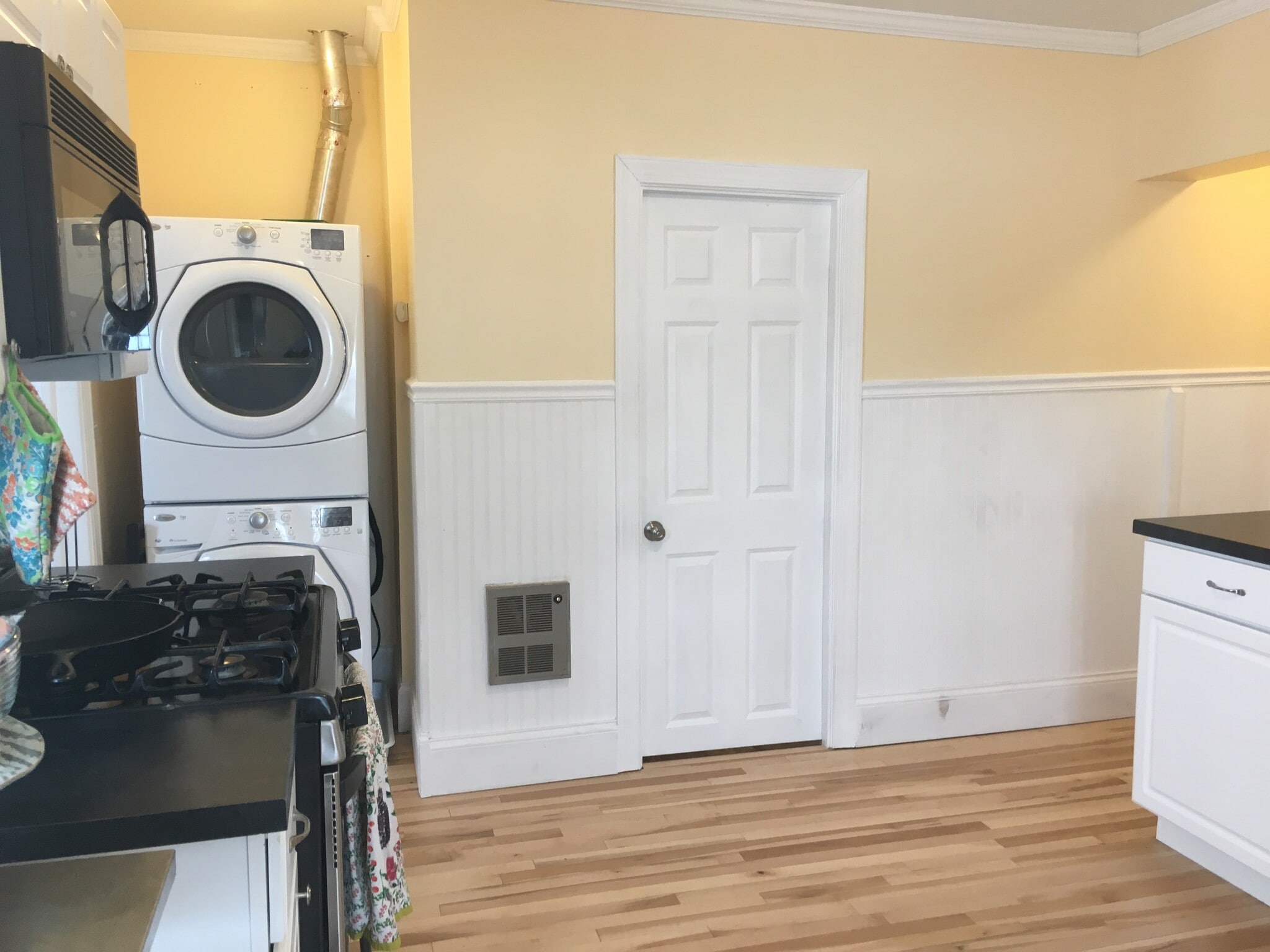 Kitchen view showing stack washer/dryer and bathroom door. - 1320 Jefferson St NE