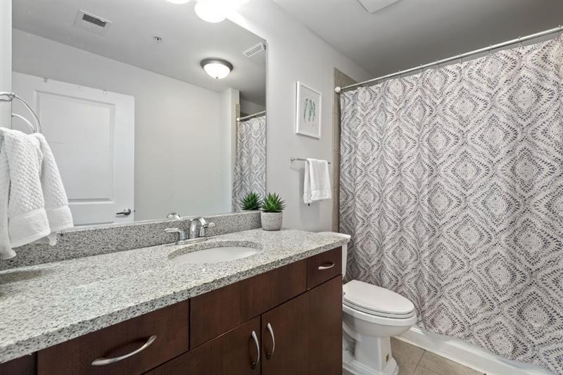 Spacious Bathroom with Granite Surfaces and Cherry Wood Cabinets - 860 Peachtree St NE