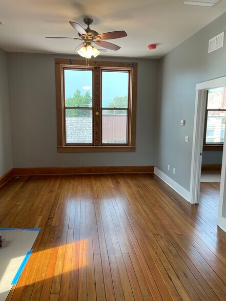 One bedroom looking north into living space. Restored original windows overlooking downtown Keota.. - 204 E Broadway Ave