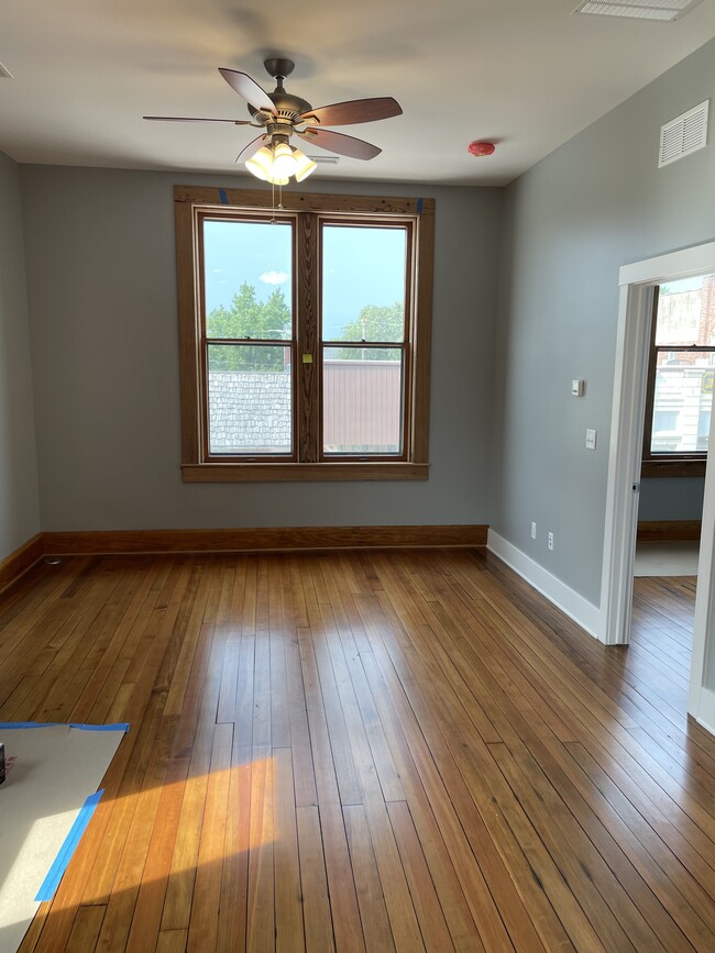 One bedroom looking north into living space. Restored original windows overlooking downtown Keota.. - 204 E Broadway Ave