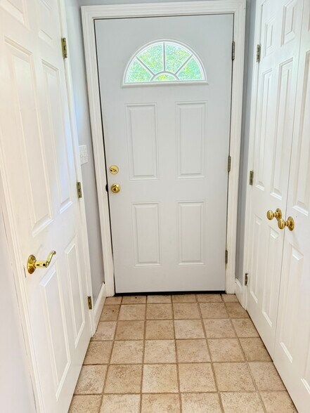 Front door with coat closet on the left & linen closet on the right - 20 Partridge Ln