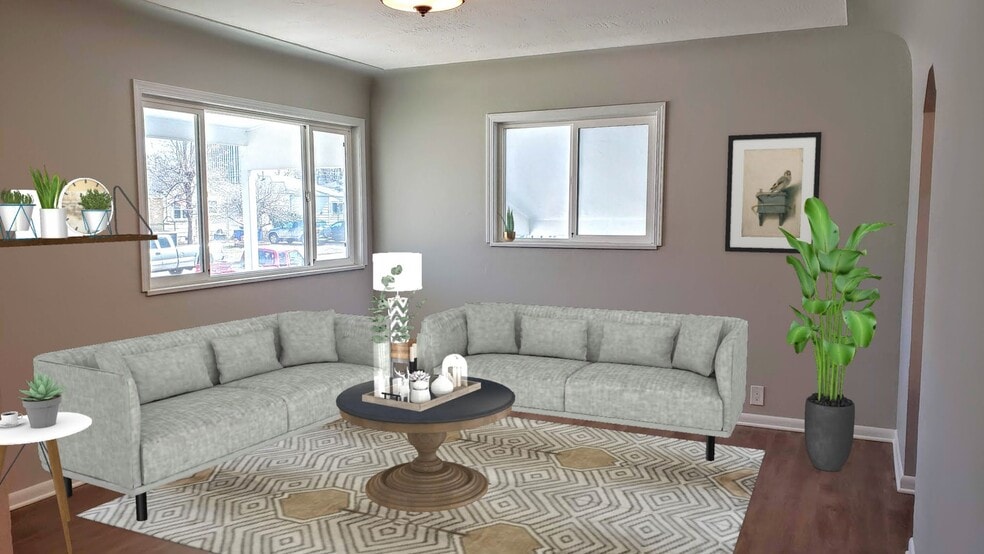 Living room full of charm from coved ceilings, luxury vinyl plank flooring, and a vintage light! - 3155 S Fox St
