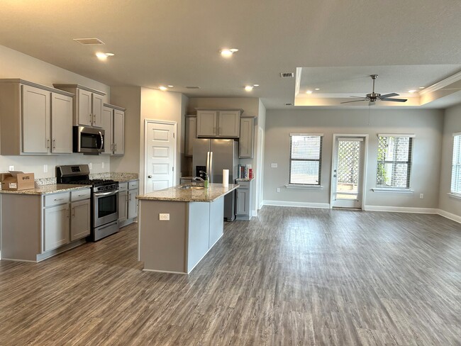 Open concept kitchen/living/dining area with center island to offer additional seating - 31524 Plover Ct