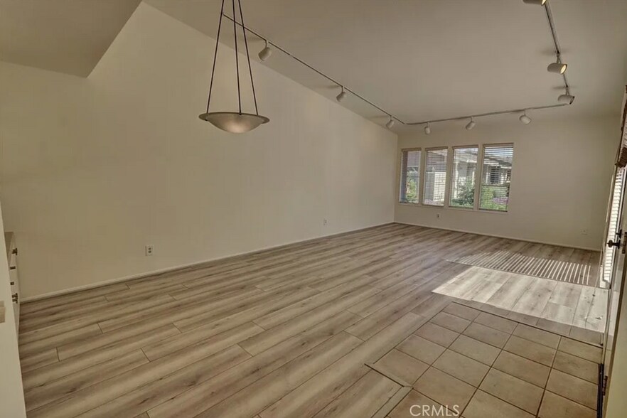 Living room & dining room with vaulted ceiling, NEW vinyl plank flooring and greenbelt view. - 8566 Larkhall Cir