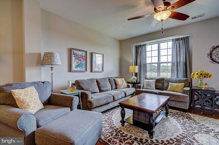 Living room with spacious seating with the view of a neighboring cornfield. - 476 N Palace Dr
