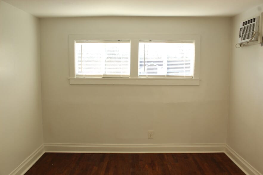 The front bedroom has high windows, which gives the room lots of wall space for furniture placement. - 1309-C Jones Avenue