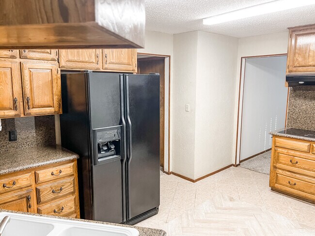 Kitchen with new countertops, new tile, fridge, single oven and cook top. - 400 Pine Dr