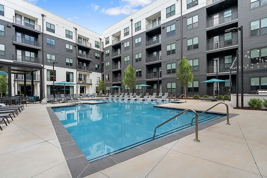 Resort-inspired saltwater pool with sun shelf and grilling stations - Auden Apartments