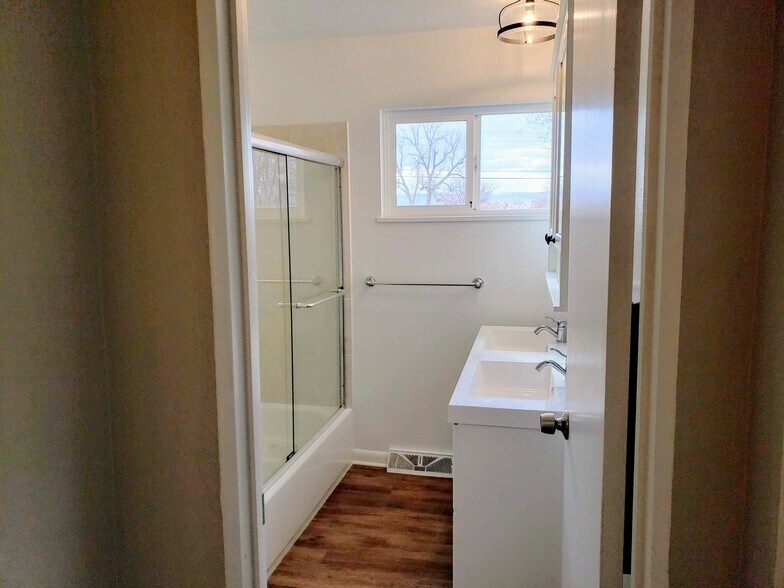 bathroom with tub and glass shower doors - 3155 S Fox St
