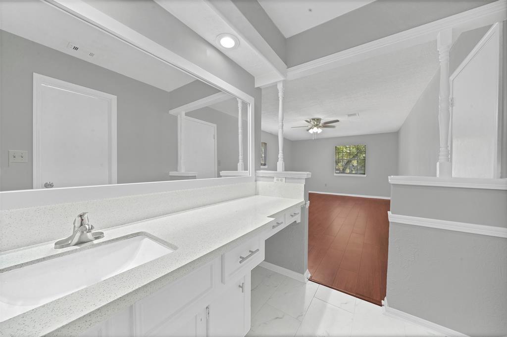 Primary bedroom with bath attached, wood floors, and ceiling fan - 5703 Green Timbers Dr