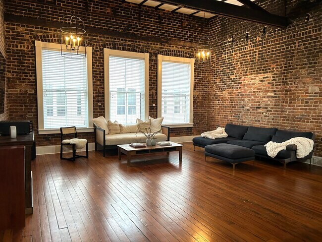 Open floor plan living room with 18ft ceilings, 75in TV, and twin size daybed. - 20 W Oglethorpe Ave