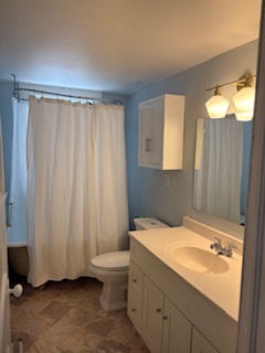 Updated bathroom with new storage, toilet, and light fixture - 381 Huntington Ave