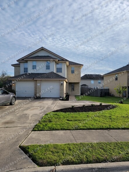Townhome with a large driveway and newly planted shrubs - 2874 Southampton Way