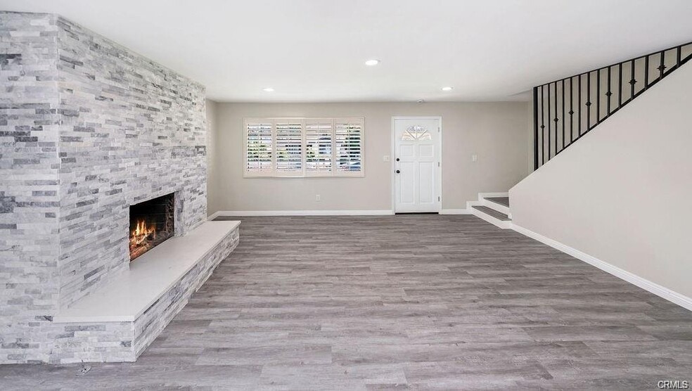Bright and spacious living room with stacked stone fireplace in a sleek coastal color palette - 2323 Harriman Ln