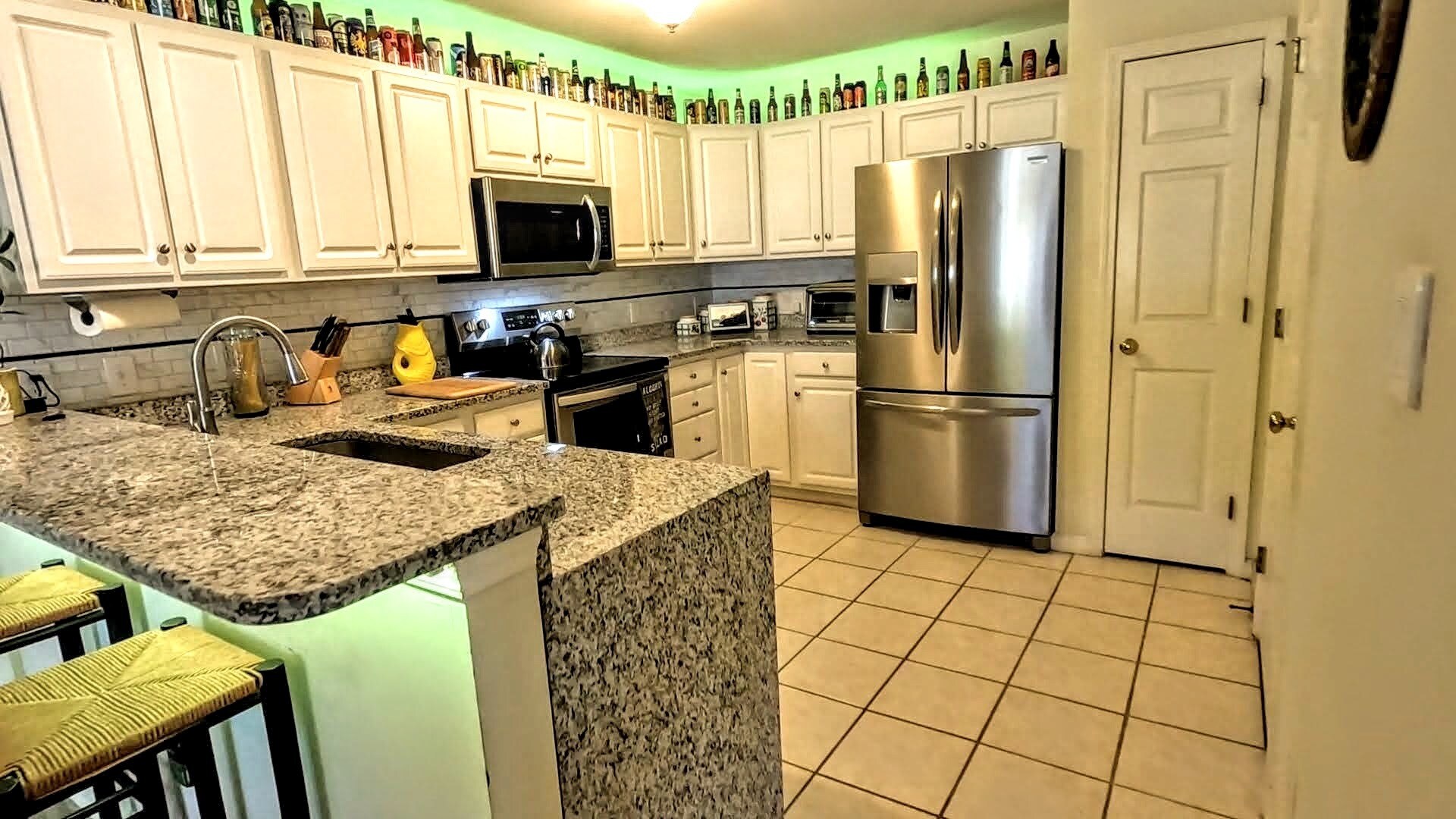 View of the dining and living areas from behind the bar in the kitchen. Note the entrance to the pri - 424 Commerce Ave