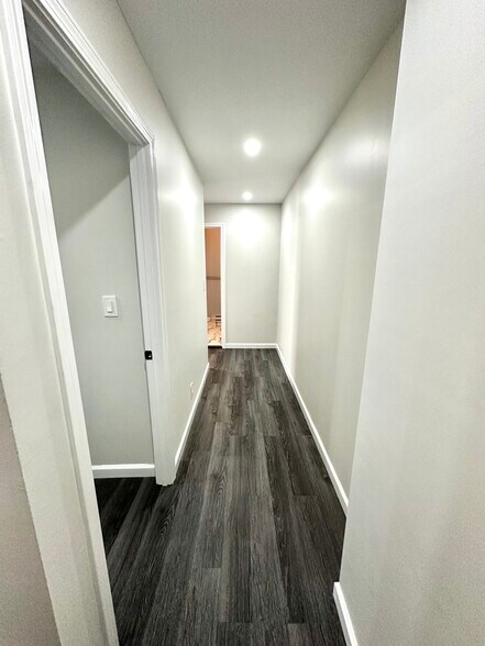 lower floor hallway. two bedrooms along the left and the bathroom straight down the hallway - 388 S Main St
