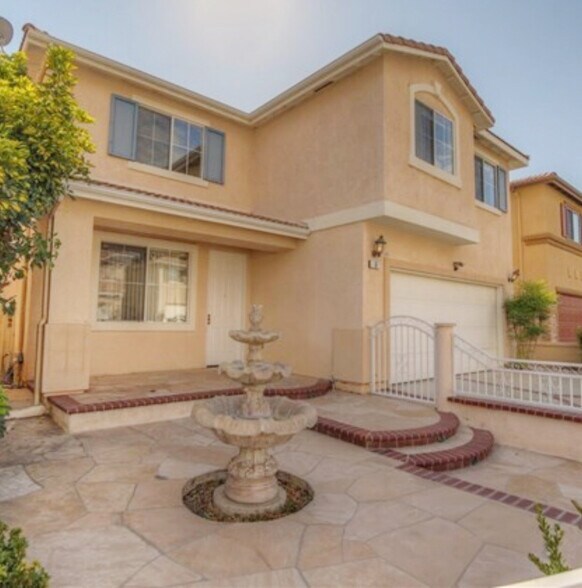 Water fountain in the front yard surrounded by white fenced gate. - 6 Red Coat Pl