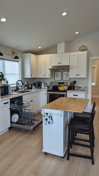 Open kitchen with full amenities, stove, dishwasher, large fridge with ice maker, garbage disposal. - 3240 29th Ave W