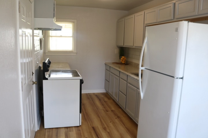 Kitchen with countertops, cabinets, beveled edge backsplash, refrigerator and electric oven/stove. - 1439 N Olympia Ave