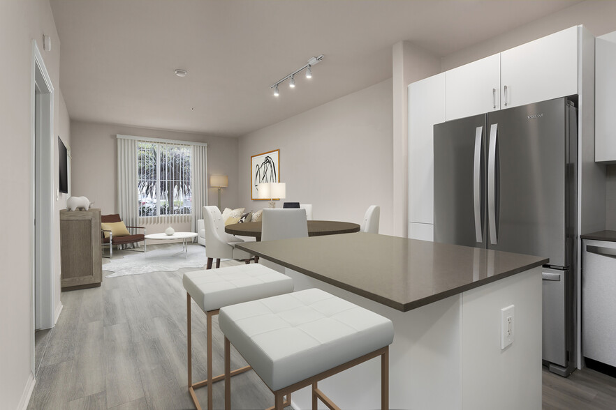 Renovated Package I kitchen with quartz countertops, white cabinetry, stainless steel appliances, hard surface vinyl plank flooring, and tile backsplash - Avalon Playa Vista