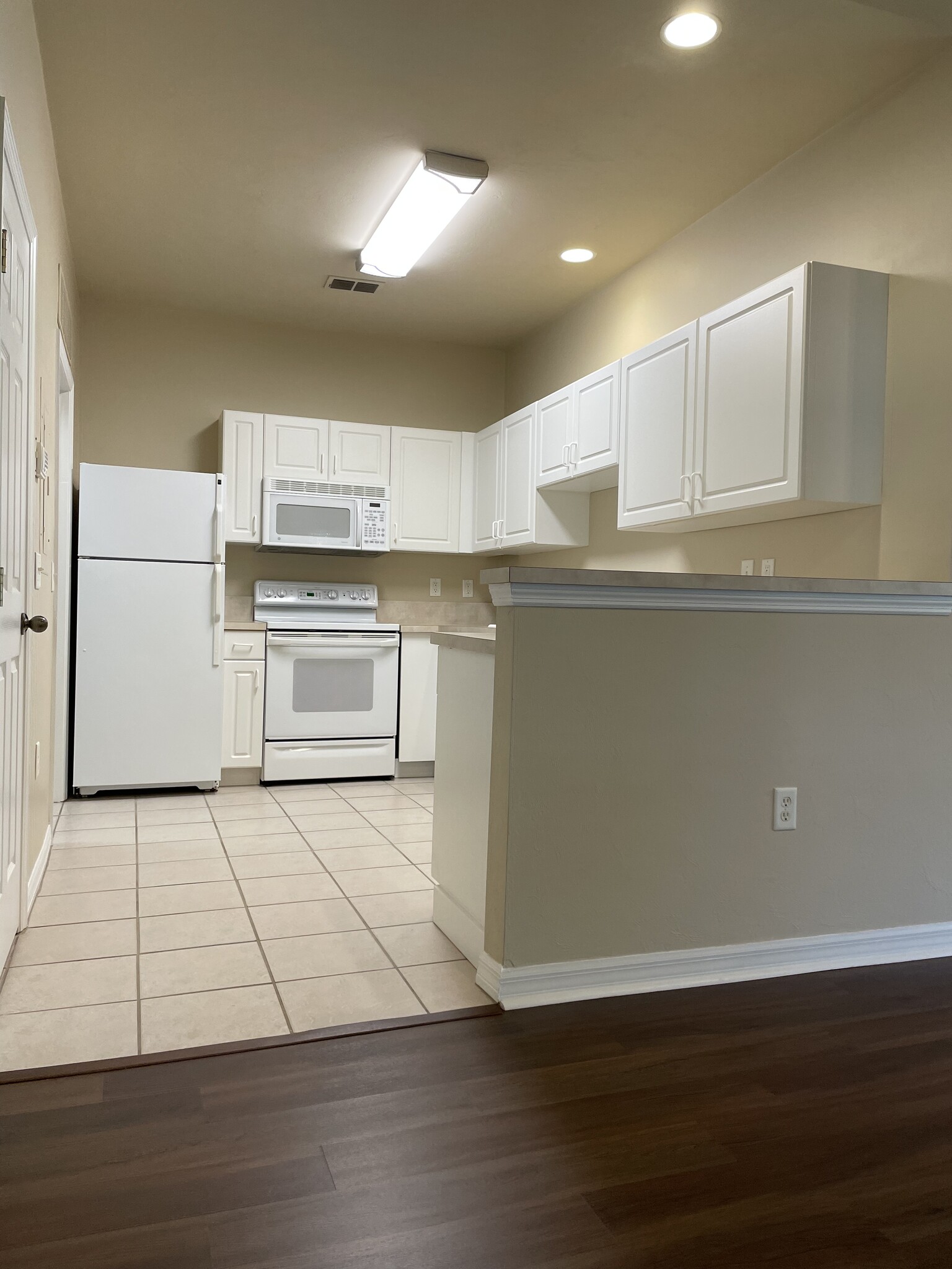 The 3 wall kitchen opens over a half-wall to the combined dining and living room. - 13200 W Newberry Rd