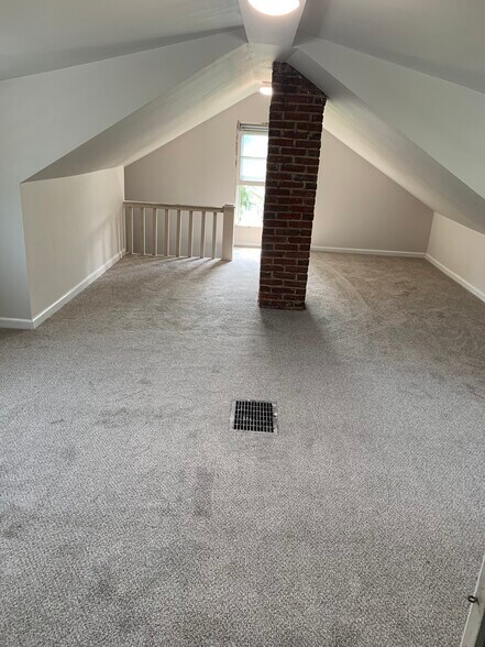 Newly carpeted upstairs bedroom has a walk-in attic for closet and storage. - 126 E. Ormond Ave