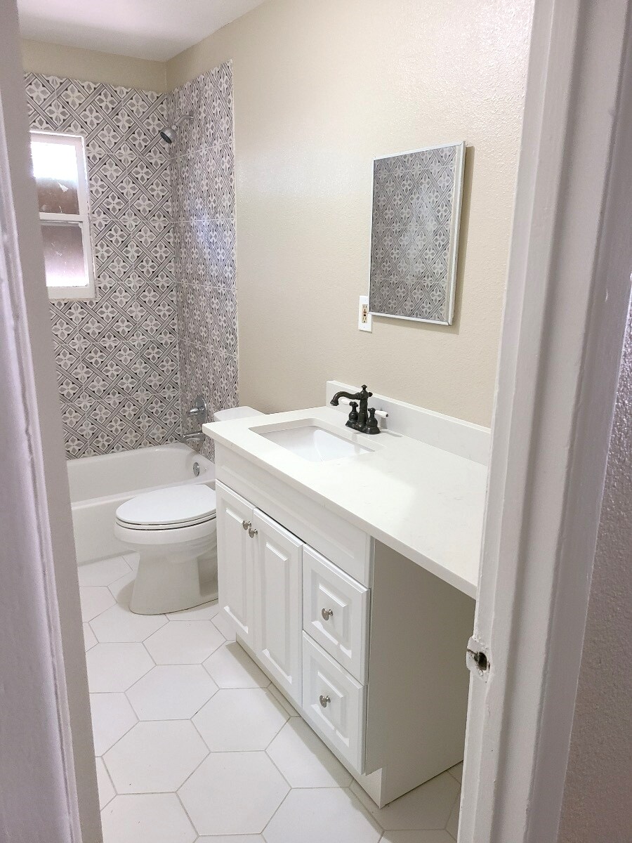 Renovated full bathroom with tub and extra large vanity. - 4244 Asbury Ave