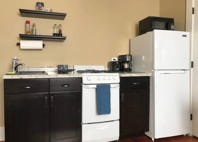 Kitchenette with full fridge, stove, sink, microwave and coffeemaker - 4685 Lotus St