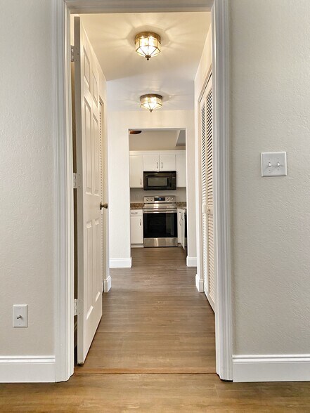hall: closet on the right side, the laundry unit is on the left side. - 1096 Woodshire Ln