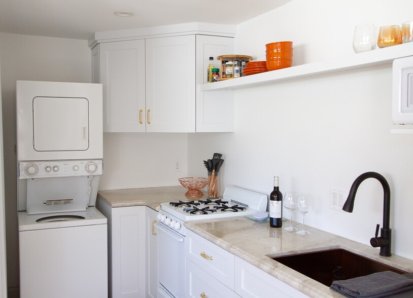 A full kitchen with: French brass sink, ample storage, washer/dryer, gas stove/oven, fridge/freezer. - 2150 Euclid Ave