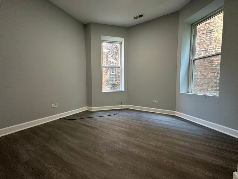 Spacious bedroom with a tall window and neutral paint - 5653 S May St