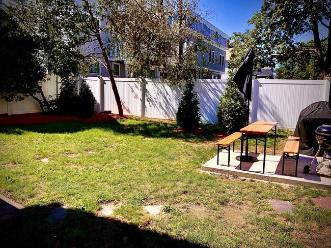 Professionally landscaped backyard with patio. Shared. White vinyl fence throughout. - 58 S Waverly St