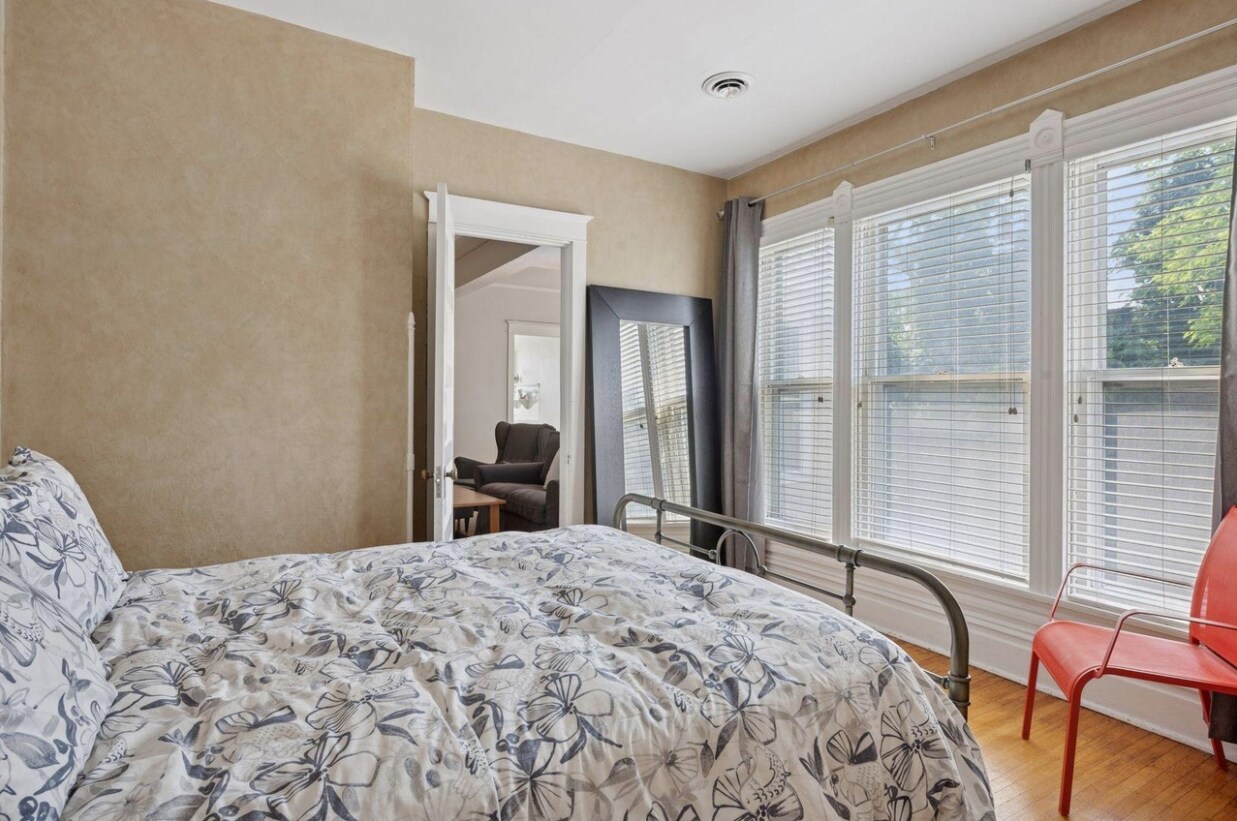 Bedroom, showing floor-to-ceiling south-facing windows. fall asleep to the sounds of the waterfall - 2601 Portland Ave