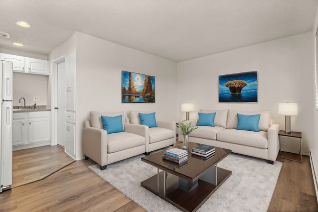 Inviting living room, virtually staged to highlight modern furniture, bright accents, and a warm, open layout. - Highland Court Apartments