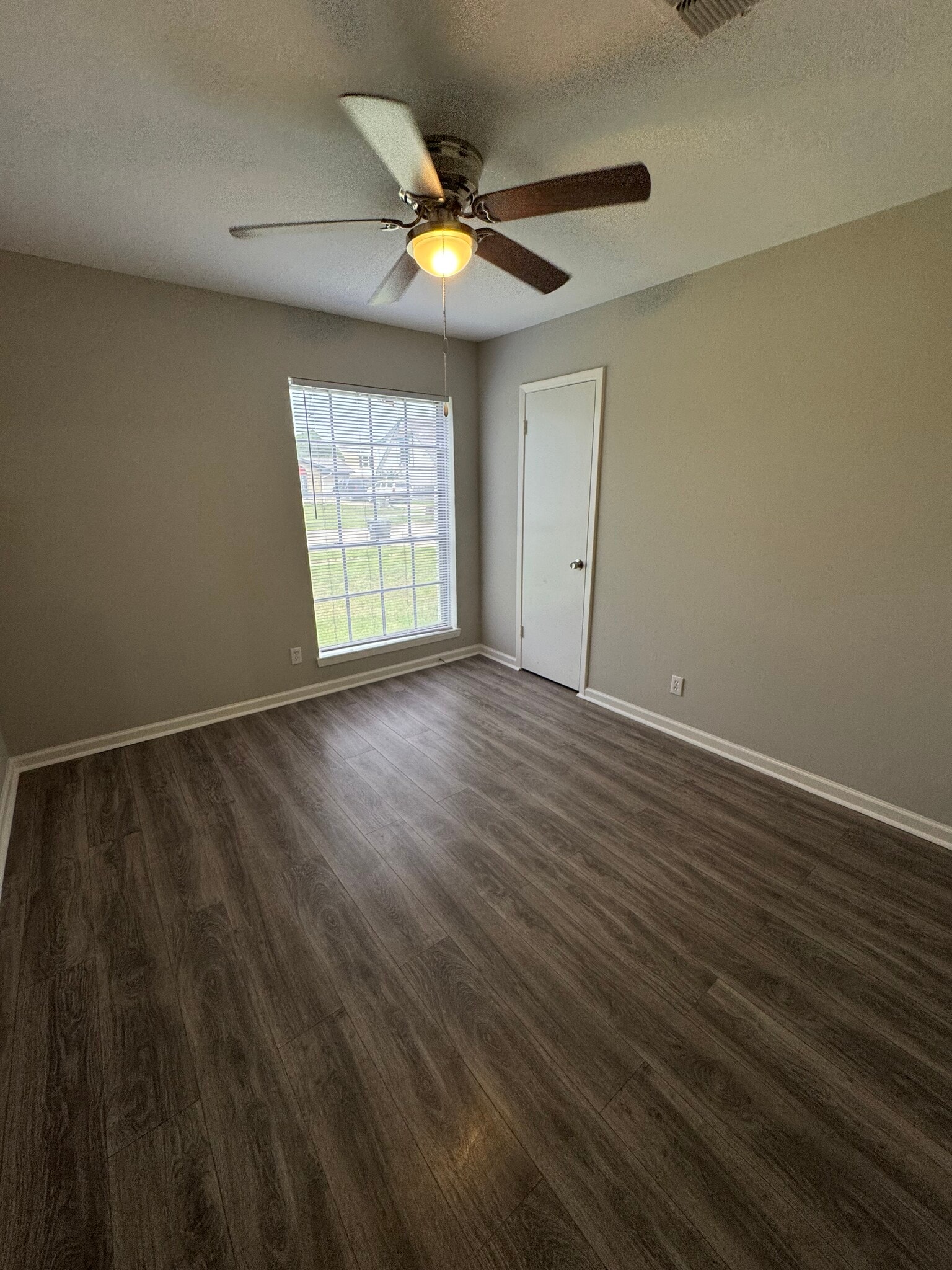 Front-facing bedroom with tons of natural light and a ceiling fan for comfort. - 11927 Troulon Dr