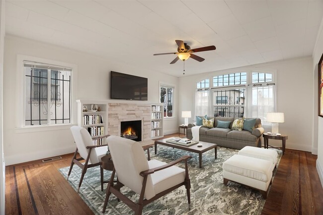 Large windows illuminate the space with the original floors of ornate in-lay wood. - 2108 E 23rd St