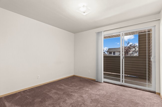 Bedroom with convenient private balcony access. - Villas at Lawrence