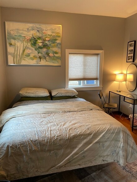 Queen size bed in bedroom downstairs. - 438 E 7th St