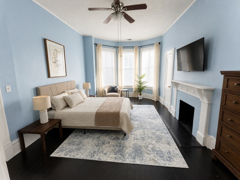 Spacious furnished bedroom with queen bed and bay windows - 319 W 33rd St