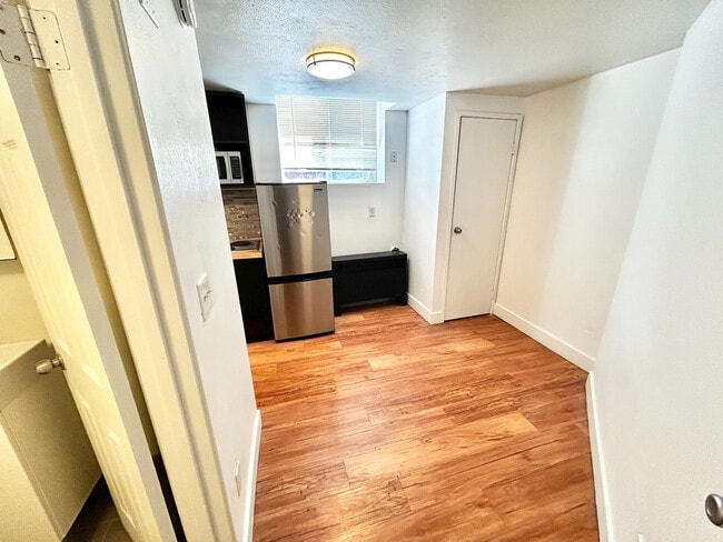 Inviting kitchen space with sleek stainless steel appliances, abundant natural light, and elegant wood flooring. - Plaza West