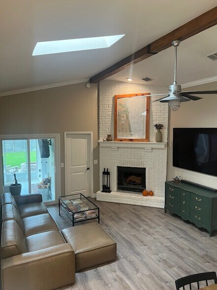 Vaulted ceilings, brick fireplace, and patio access for easy flow. - 953 13th Ave S