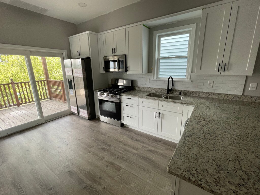 Unit two: open-concept kitchen with all new appliances, cabinets, granite, and finishings and view - 34 Falcon St