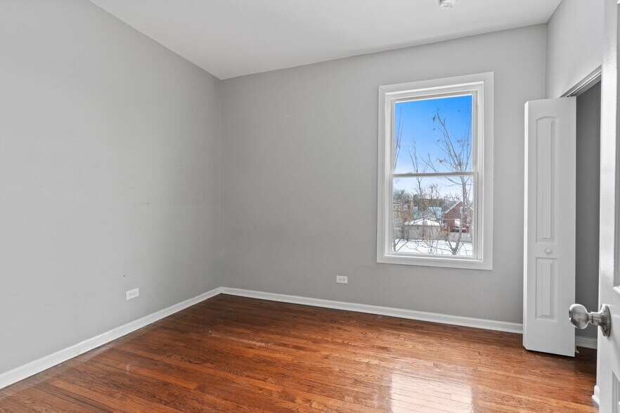 2 - Sunlit bedroom with hardwood floors and closet. - 7028 S Peoria St