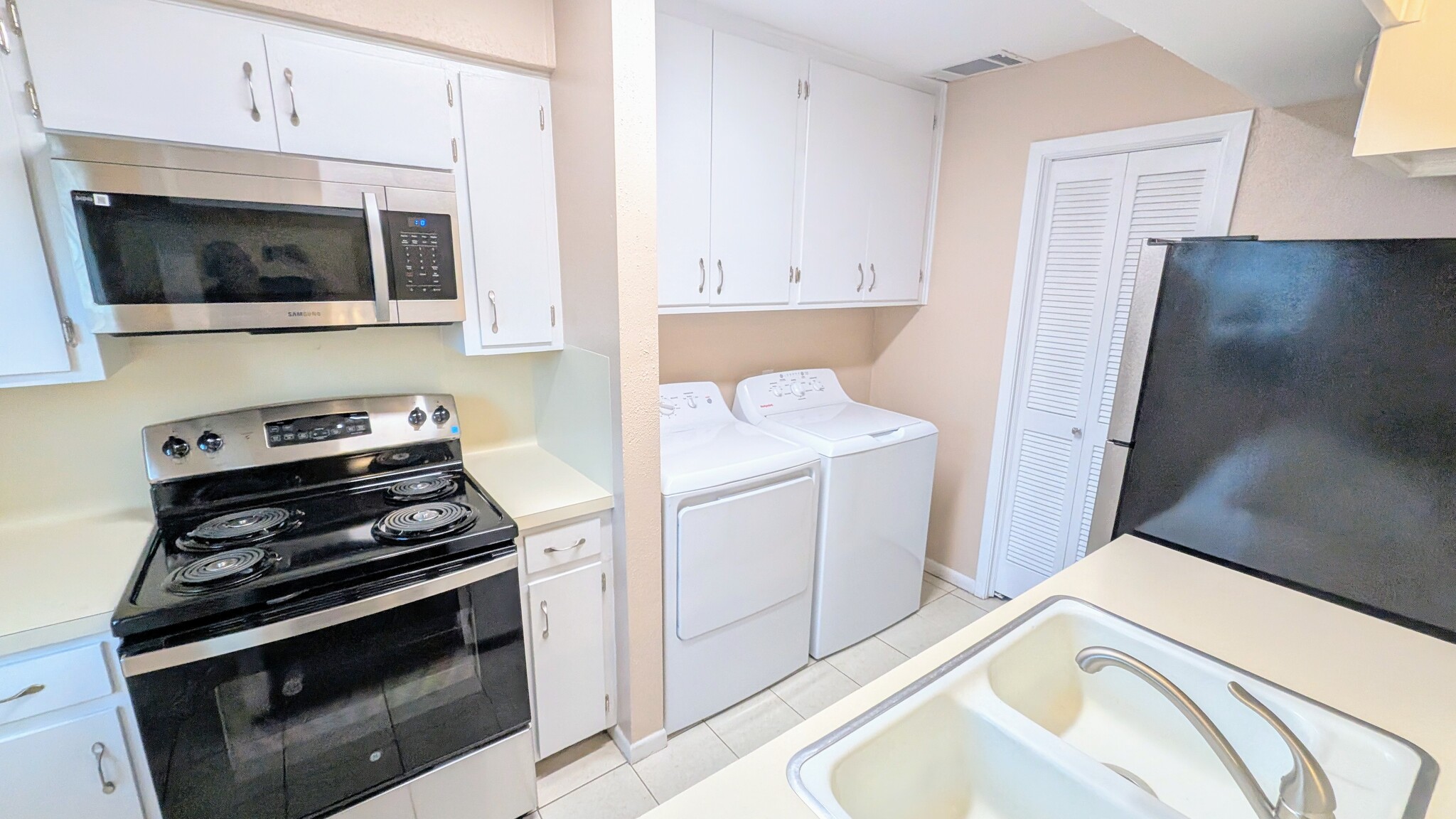 Galley kitchen with all new appliances, including washer and dryer, and tons of storage! - 813 Clubside Dr