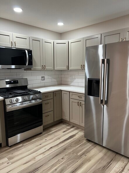 Side by side refrigerator w/ice maker in door. Mocs cabinets with gold pulls - 408 John St