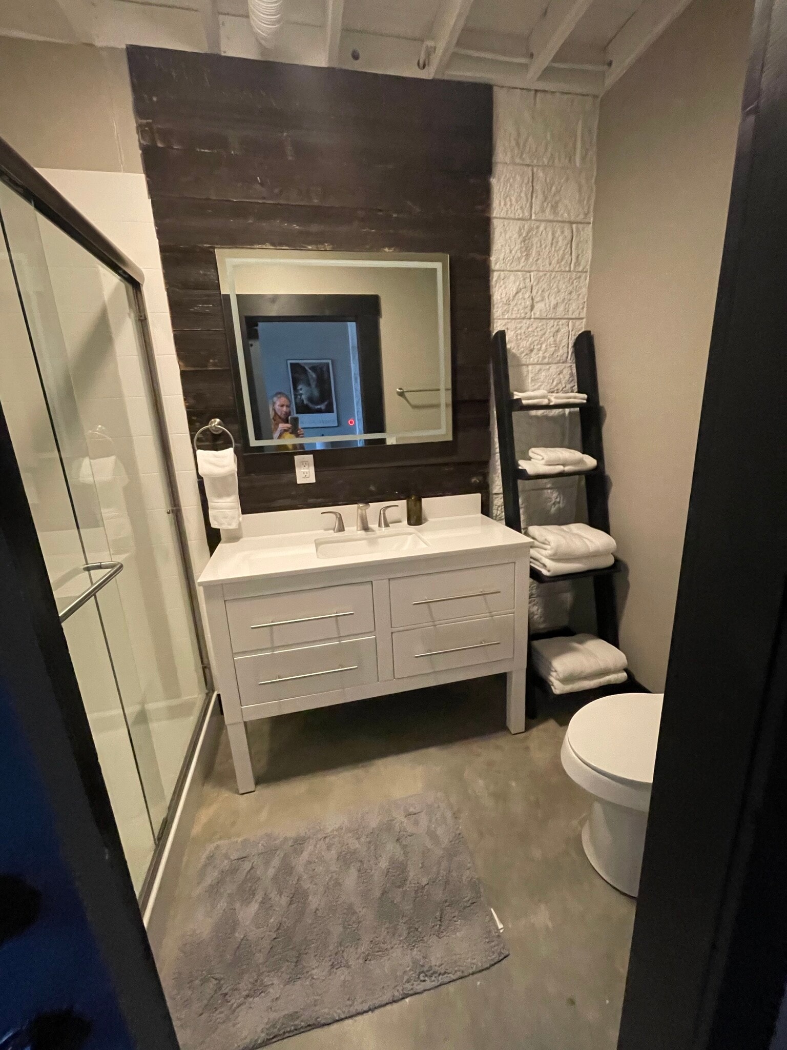 Bathroom with shower, lighted mirror, towels, and toilet paper. - 475 S Hickory St