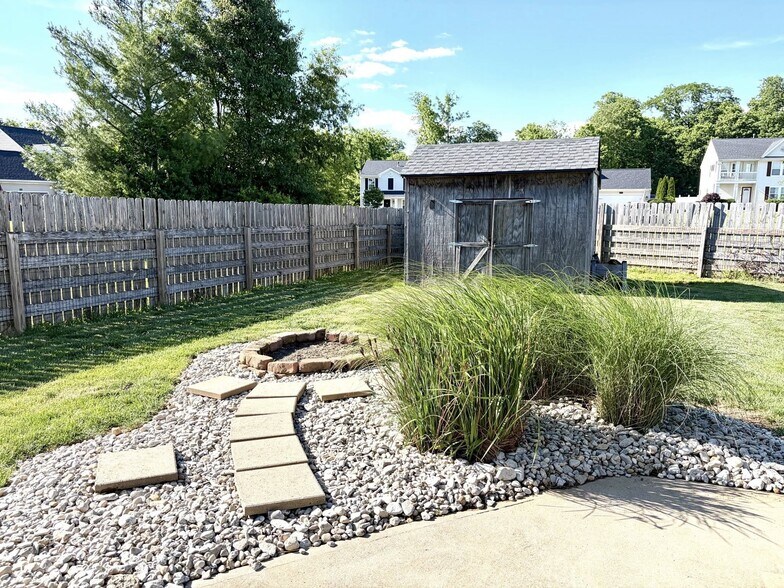 Fenced back yard with large concrete patio and fire pit - 1200 Bugle Bluff Ct